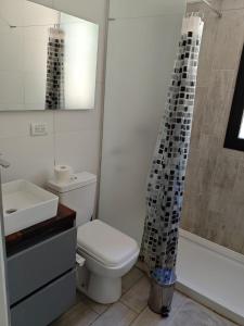 a bathroom with a toilet and a shower curtain at Entre Montañas - Vista Calma in Potrerillos +31 photos