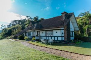 a house on a hill with a grass yard at The Cottage - Assure your Tickets for the Ella train journey in Ambawela