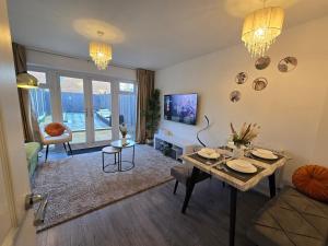 a living room with a table and a couch at Cozy Gem Luxury House in Marston Green