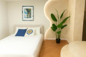 a bedroom with a white bed and a plant at Jeonpo Cafe Street Near Seomyeon Entire House 2 Floors 7 Guests in Busan