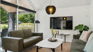 a living room with a couch and a table at Villavilla 640 - Saksild, Østjylland in Odder +16 photos