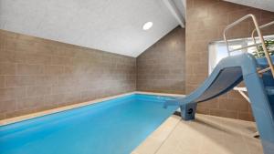 a indoor swimming pool with a slide in a room with tiles at Villavilla 596 - Rømø, Sydjylland in Høm