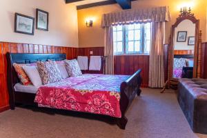 a bedroom with a bed and a couch and a window at The Cottage - Assure your Tickets for the Ella train journey in Ambawela