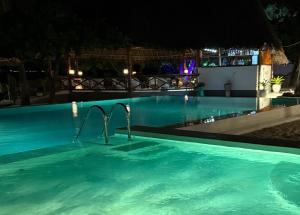 a swimming pool at night at Amani Palms by Manolo Beach Resort in Uroa +19 photos