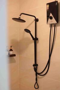 een douche met een douchekop in een badkamer bij Rungarun Residence in Ratchaburi