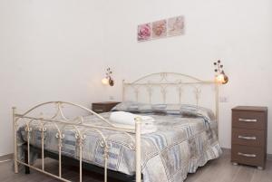 1 dormitorio con 1 cama blanca con marco metálico en Sweetsea en Castellabate