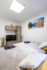 a white bedroom with a bed and a fireplace at Mátravölgy Apartmanház in Pásztó +148 photos