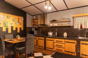a kitchen with wooden cabinets and a table with chairs at The Cottage - Assure your Tickets for the Ella train journey in Ambawela