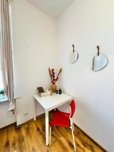 a white desk with a red chair and two lights at Pokój przy Rynku ll in Katowice +2 photos