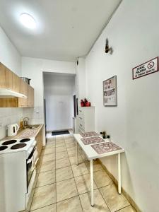 a kitchen with a stove and a table in it at Pokój przy Rynku ll in Katowice