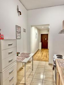 a kitchen with a table in the middle of a room at Pokój przy Rynku ll in Katowice