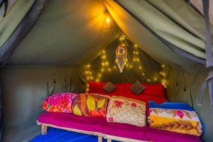 a room with a bed in a tent with lights at Himtrek Riverside Camps, Kasol in Kasol
