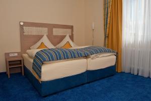 ein Schlafzimmer mit einem großen Bett mit blauem Teppich in der Unterkunft Am Schlosspark in Worms