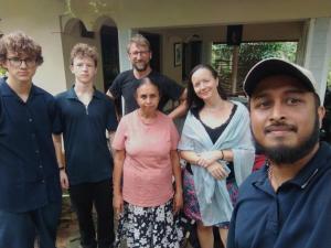 a group of people standing in front of a house at Rainforest Nature House in Deniyaya