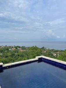 a swimming pool with a view of the ocean at Villa Panorama Amed in Ambat