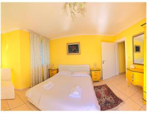 a bedroom with a white bed and yellow walls at Casa Oasa Boutique rooms Pool near Koper in Koper +29 photos