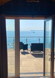a view of the ocean from a room with sliding glass doors at 4 Sinclair bay lodges in Keiss