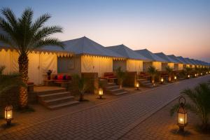 a row of tents with lights and palm trees at Sunrise Resort Jaislamer in Jaisalmer