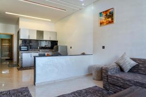 a living room with a couch and a kitchen at 2 Voies Résidence in Dakhla