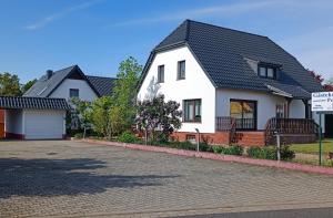 a white house with a black roof at Gästehaus Müller in Hohenleipisch