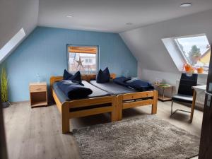 a bedroom with a large bed with blue walls at Gästehaus Müller in Hohenleipisch