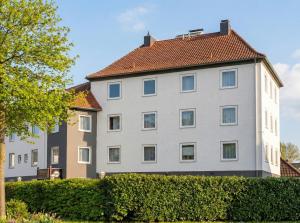 a large white building with a red roof at Hotel Schultheiss Hameln in Hameln