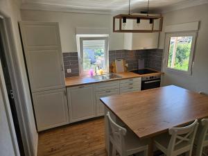 a kitchen with a sink and a wooden table at Relaxing Riverside Escape & Stunning Sunset Views in Santa Comba Dão