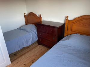 a bedroom with two beds and a wooden dresser at Relaxing Riverside Escape & Stunning Sunset Views in Santa Comba Dão