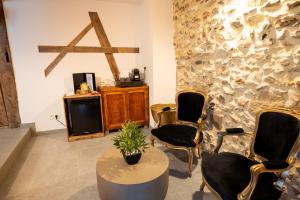 a room with chairs and a table and a tv at les jardins de la ferme in Soumagne