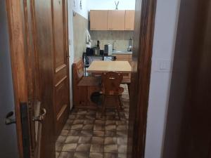 a small kitchen with a table and a chair in a hallway at I Pelosetti in Calalzo