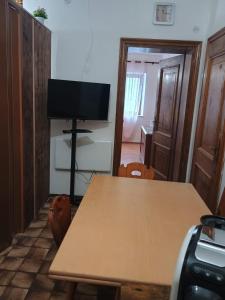 a dining room with a table and a television at I Pelosetti in Calalzo