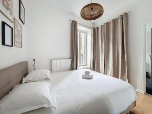 a white bedroom with a bed and a window at Appartement centre historique 4 pers in Clermont-Ferrand