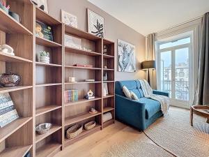a living room with book shelves and a blue chair at Appartement centre historique 4 pers in Clermont-Ferrand