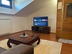 a living room with a coffee table and a flat screen tv at Fusero1 relax vero borgata fusero 20 giaveno in Coazze