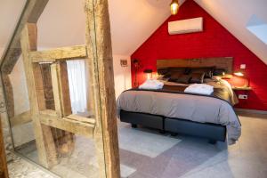a bedroom with a bed with a red wall at les jardins de la ferme in Soumagne +93 photos