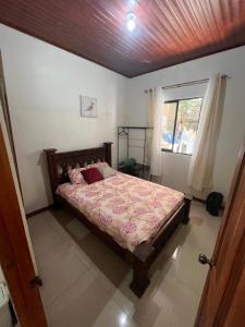een slaapkamer met een bed en een raam bij Apartamentos casco in Heredia +2 foto's