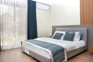 a bedroom with a bed with blue pillows and a window at Silver Bay Club House in Urla