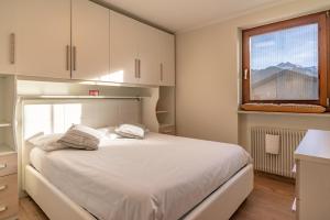 a bedroom with a white bed and a window at Trilo Ciasa Brìma in Carano