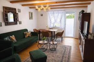 ein Wohnzimmer mit einer grünen Couch und einem Tisch in der Unterkunft MPK Motorsport Apartment in Waldsassen + 7 Fotos