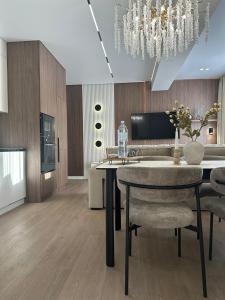 a dining room with a table and chairs and a chandelier at RentNow Apartments Luxury Apartment with Balcony and Parking in Chişinău