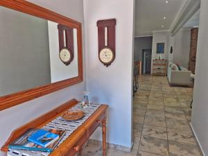 a hallway with two clocks on the wall and a table at Brett's Place in Warmbaths