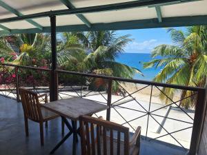 a table and chairs on a balcony overlooking the ocean at The Archipelago Waterfront in Zanzibar City