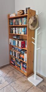 a book shelf filled with books with a hat on it at Brett's Place in Warmbaths