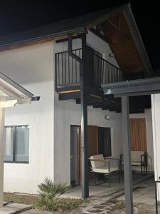 a house with a balcony with a table and a chair at M Town cotagge house in Agdgomelaantkari +10 photos
