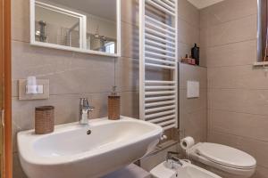 a bathroom with a white sink and a toilet at Trilo Ciasa Brìma in Carano +35 photos