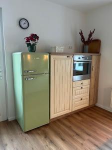 a kitchen with a refrigerator and a stove and a clock at Stadtblick Ferienwohnung in Braunlage