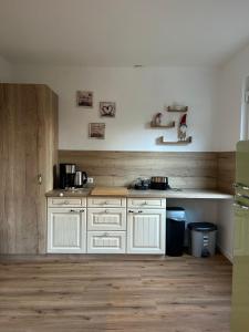 a kitchen with white cabinets and a wooden floor at Stadtblick Ferienwohnung in Braunlage