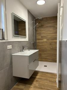 a bathroom with a white sink and a shower at Stadtblick Ferienwohnung in Braunlage +6 photos