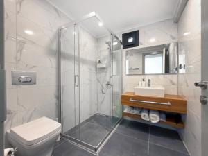 a bathroom with a shower and a toilet and a sink at Silver Bay Club House in Urla