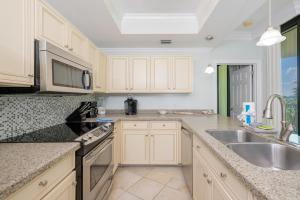 a kitchen with white cabinets and a sink at Phoenix on the Bay 1320 in Orange Beach